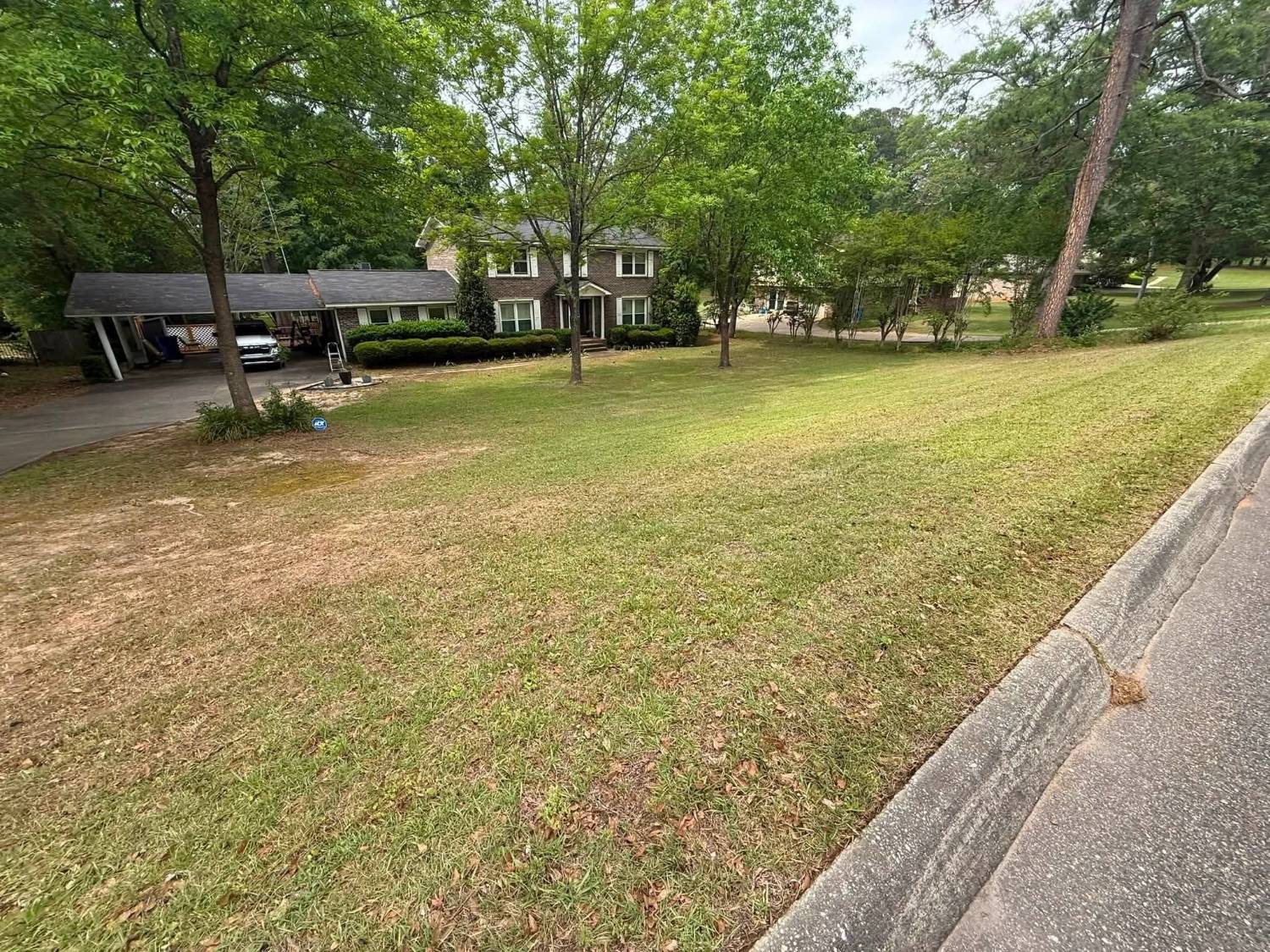 Two-story brick home with a striped lawn