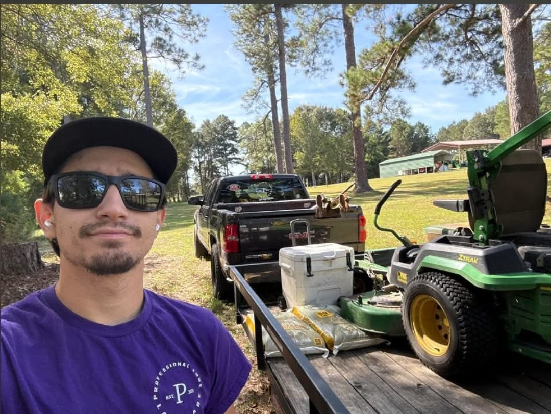 Cameron Rodriguez with his John Deere Z-Trak mower on the trailer and his truck
